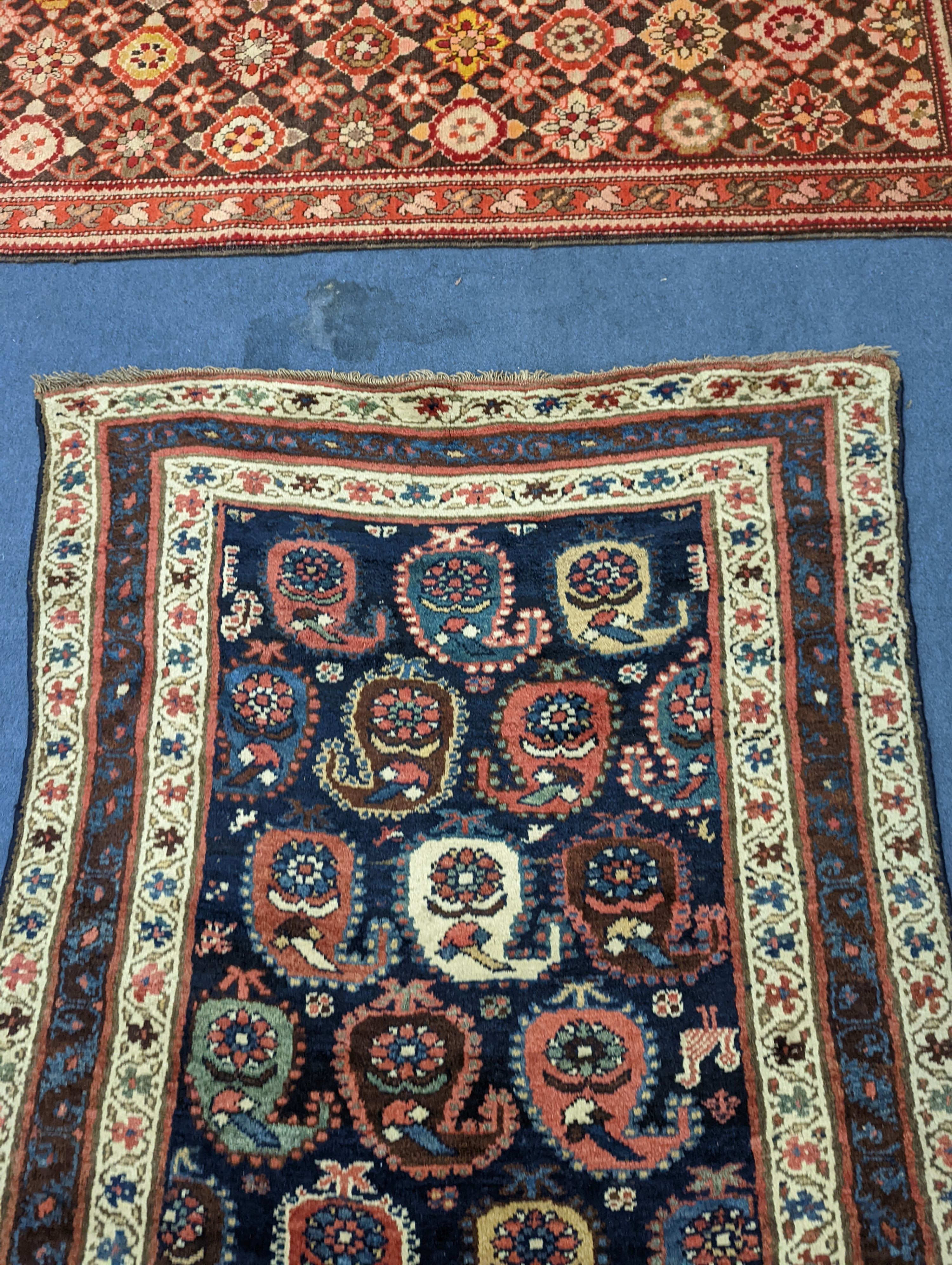 A Caucasian Karabagh blue ground runner, woven with rows of stylised boteh, figures and birds, 477 x 117cm